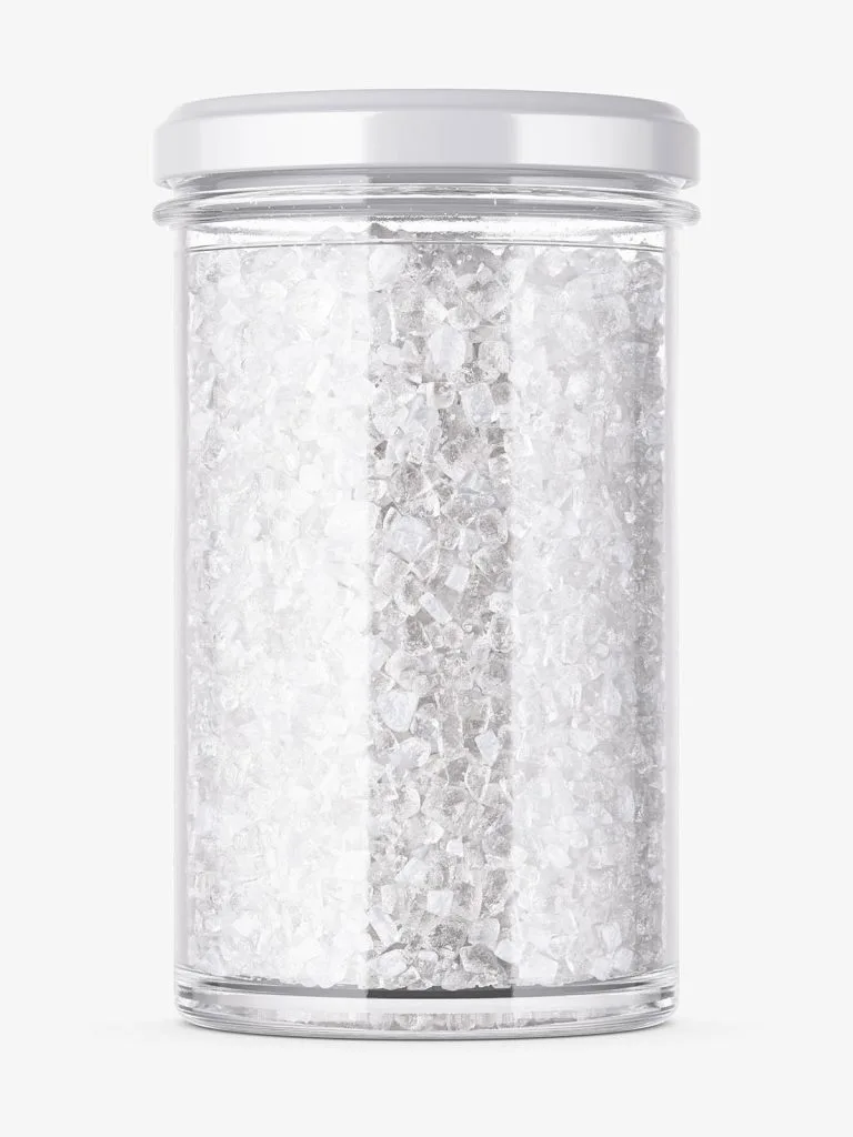 A clear cylindrical jar of pale cosmetic salt with a silver-colored lid.