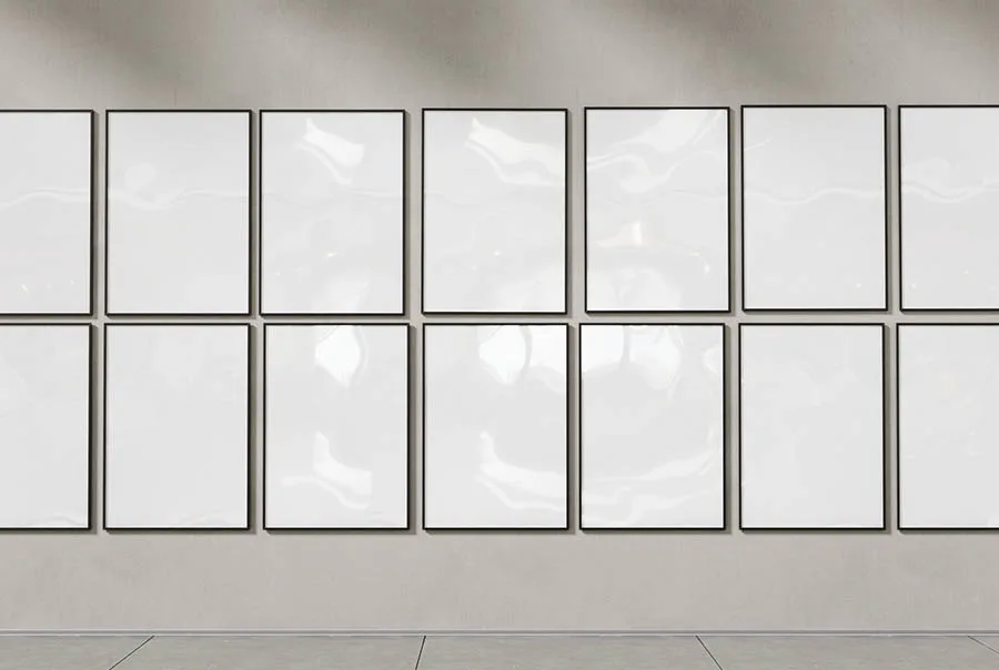 Two rows of dark-framed, pale posters on a warm-gray wall above a strip of tiled floor.